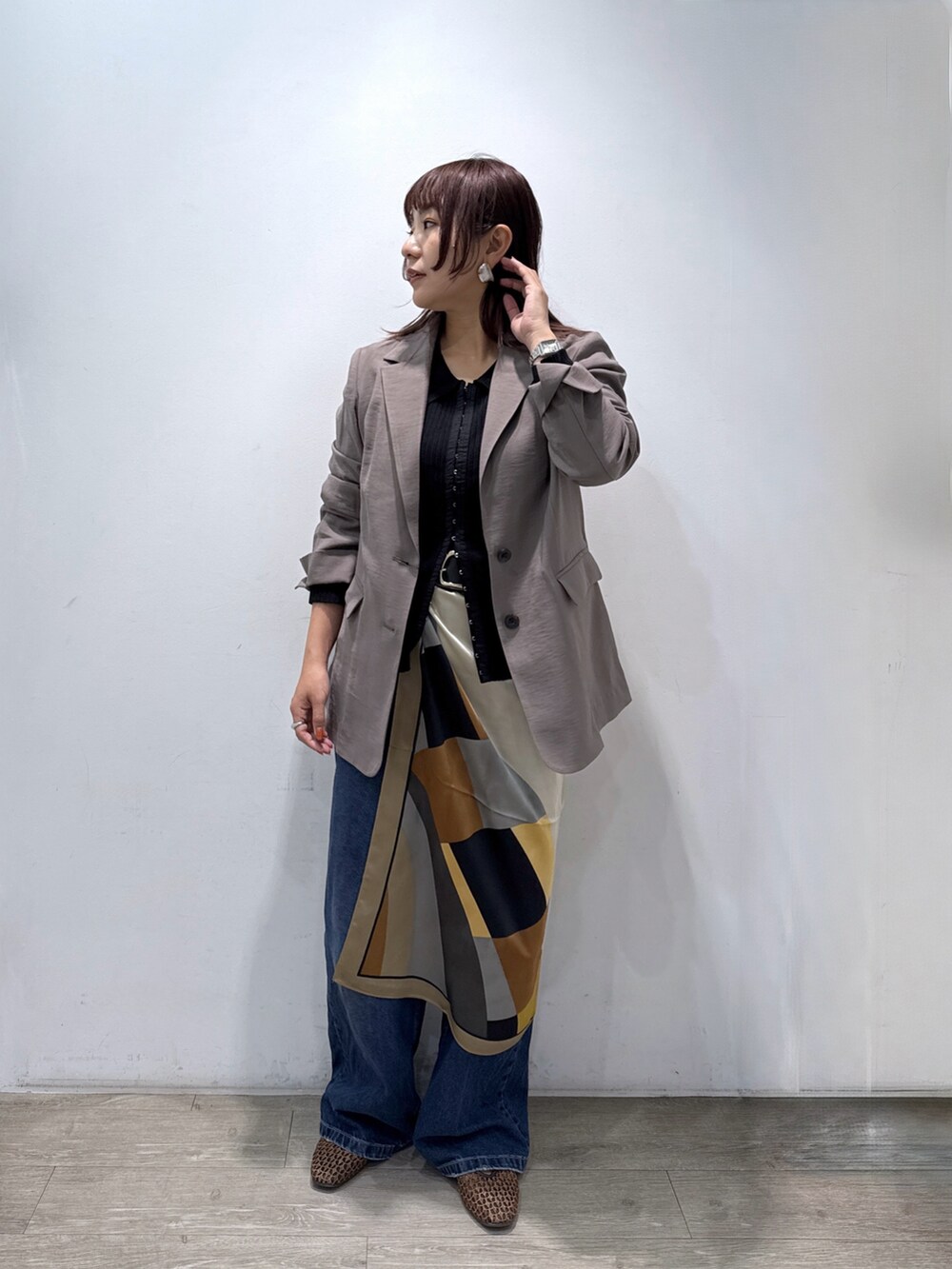 ブラック系のカーディガン/ボレロ、ブラウン系のテーラードジャケット、ブルー系のデニムパンツを着用したレディースの春コーディネートの4枚目の写真