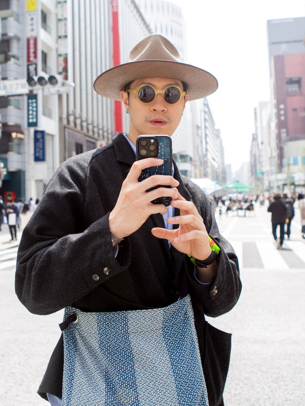 ブラック系のテーラードジャケット、ブラウン系のスニーカー、ブラック系のカーゴパンツを着用したメンズの春コーディネートの2枚目の写真