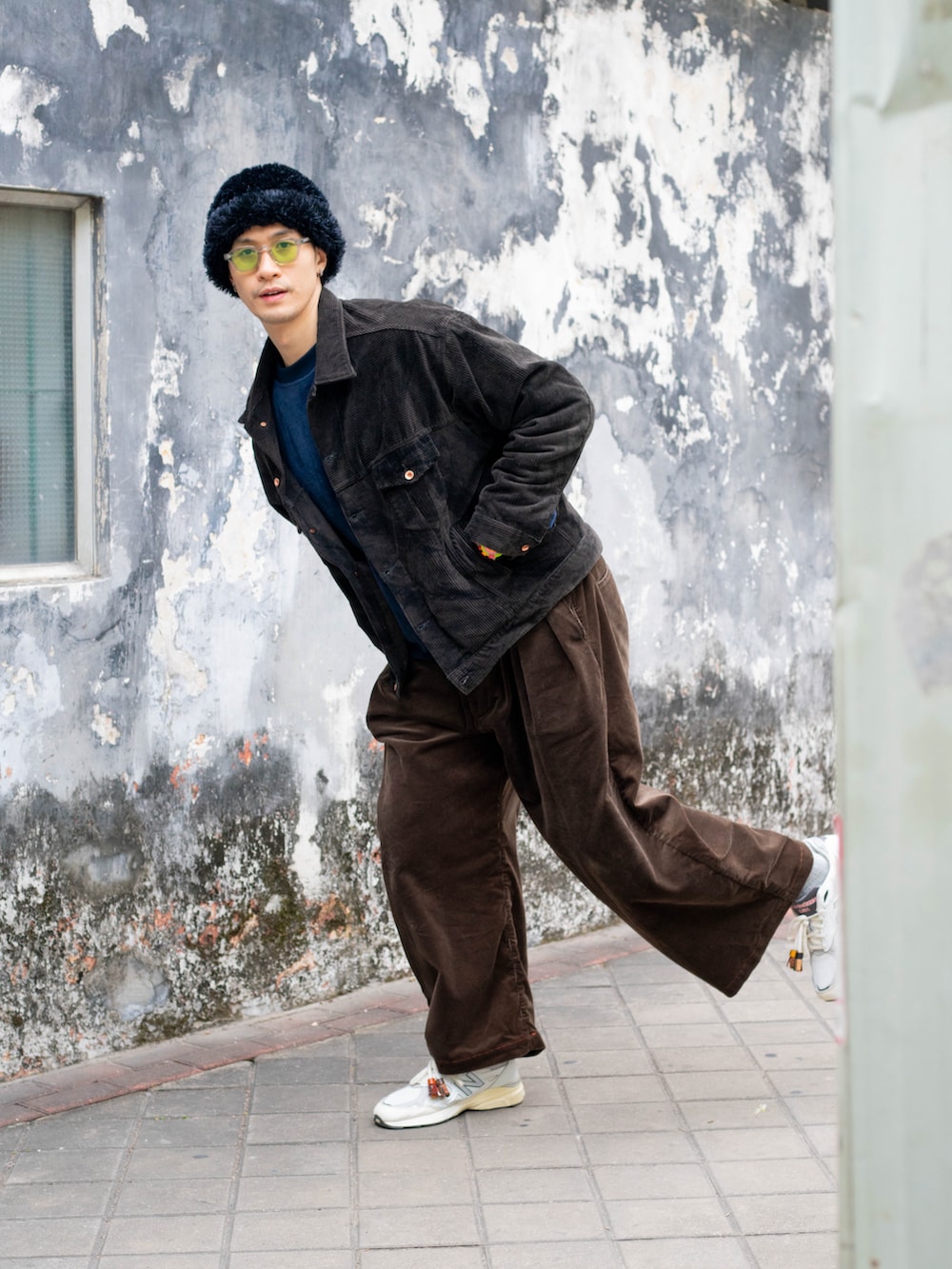 ブラウン系のその他アウター、ブラウン系のチノパンツ、ホワイト系のスニーカーを着用したメンズの冬コーディネートの2枚目の写真