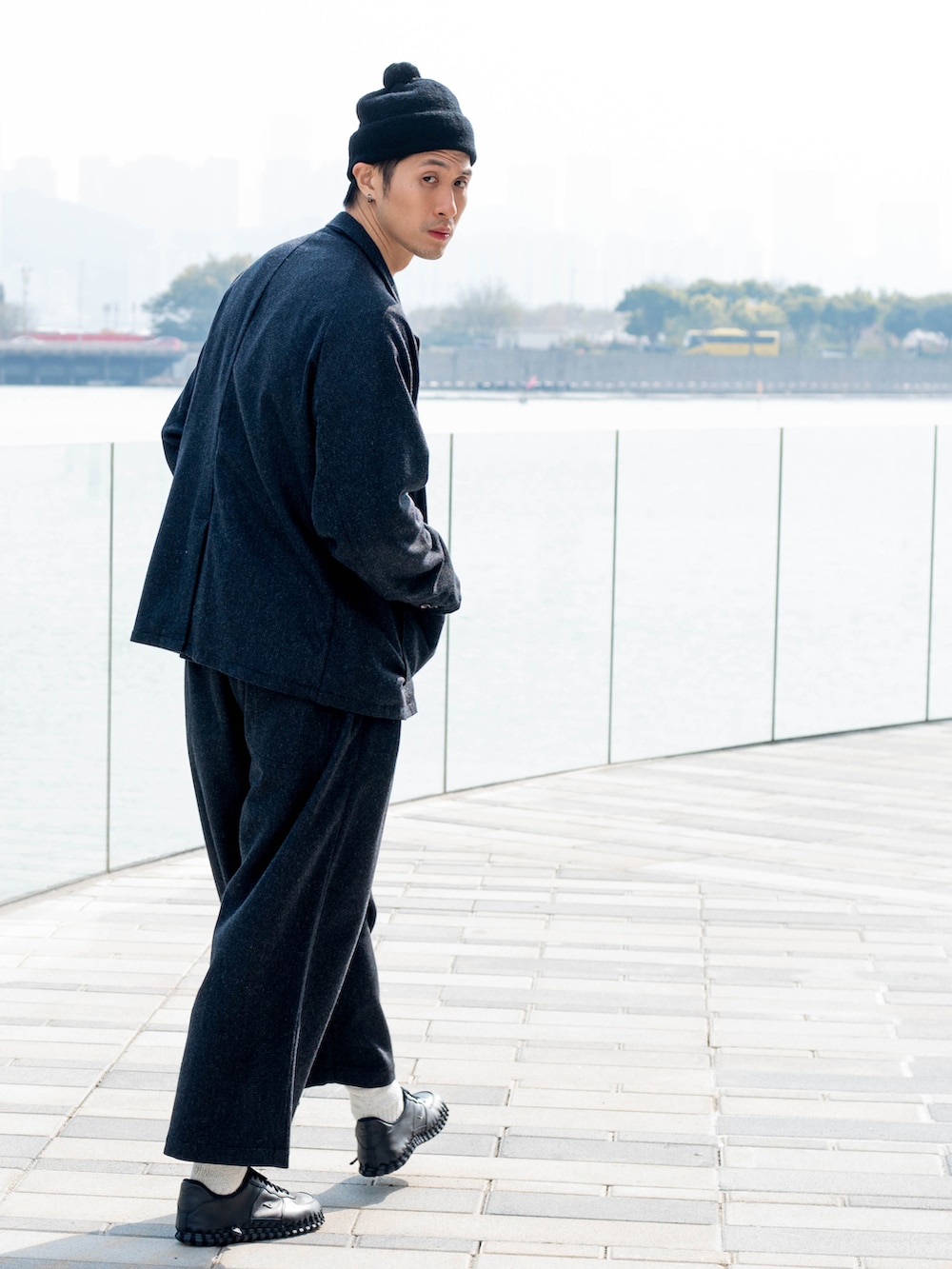 ブラック系のテーラードジャケット、ブラック系のスラックス、ブラック系のスニーカーを着用したメンズの冬コーディネートの2枚目の写真