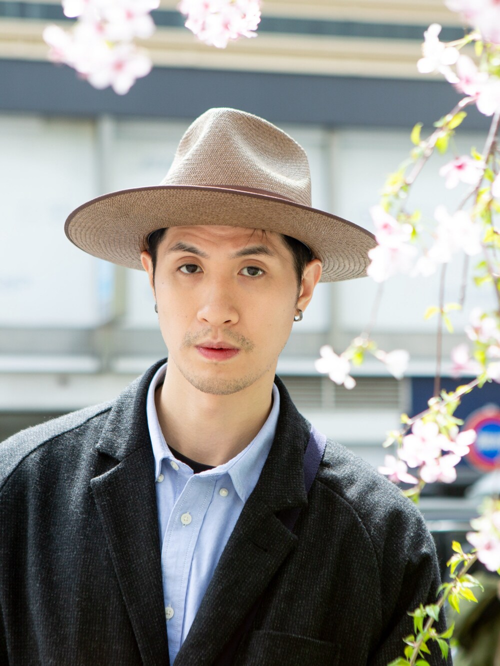 ブラック系のテーラードジャケット、ブラウン系のスニーカー、ブラック系のカーゴパンツを着用したメンズの春コーディネートの4枚目の写真