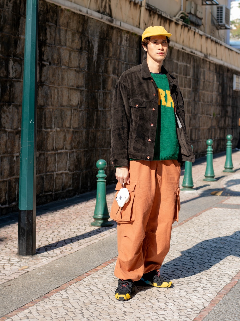 グリーン系のニット/セーター、オレンジ系のその他パンツ、ブラック系のスニーカーを着用したメンズの冬コーディネートの2枚目の写真