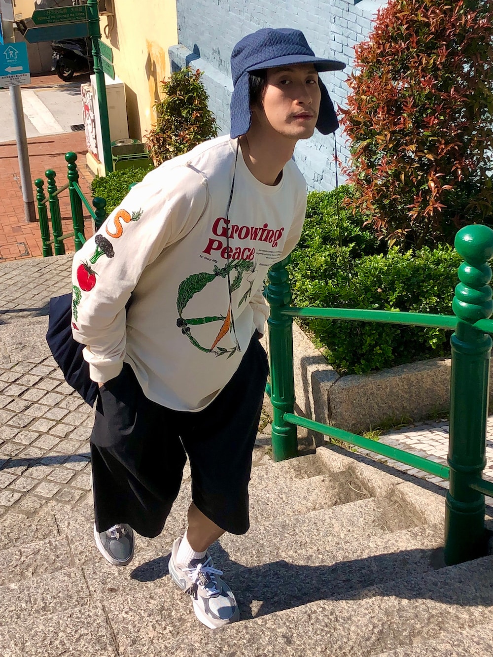 ベージュ系のTシャツ/カットソー、ブラック系のカーゴパンツ、グレー系のスニーカーを着用したメンズの春コーディネートの2枚目の写真