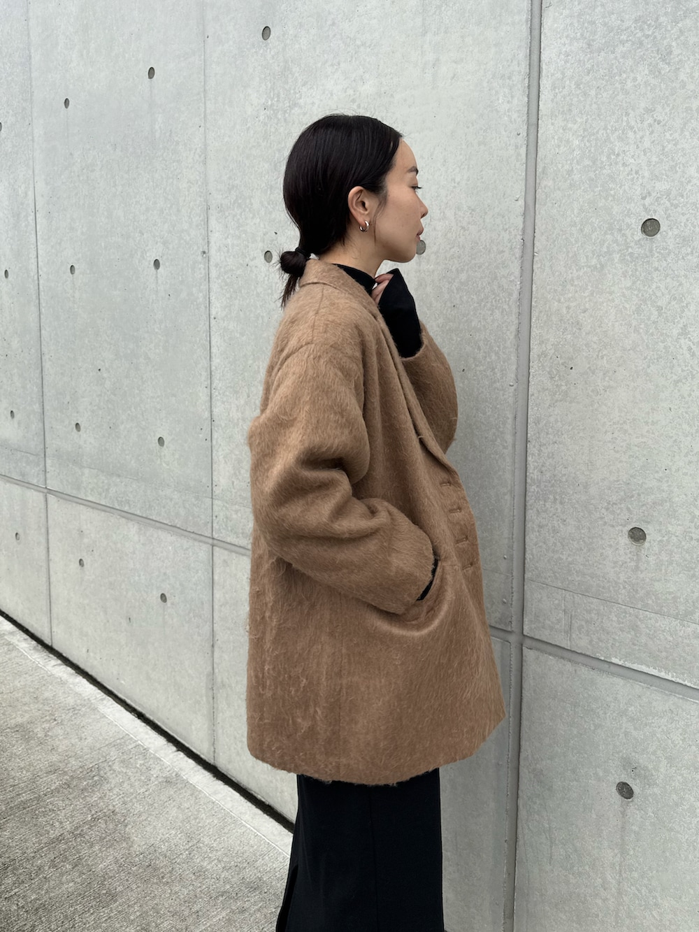 ブラウン系のテーラードジャケット、ブラック系のワンピース、ブラック系のスニーカーを着用したレディースの秋コーディネートの3枚目の写真