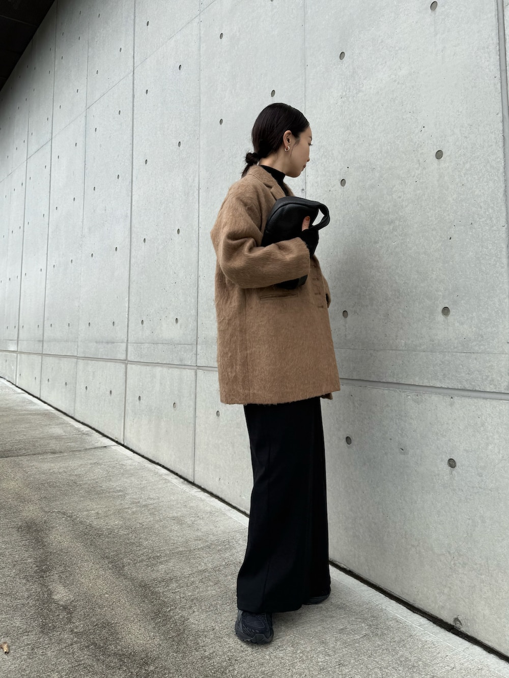 ブラウン系のテーラードジャケット、ブラック系のワンピース、ブラック系のスニーカーを着用したレディースの秋コーディネートの4枚目の写真