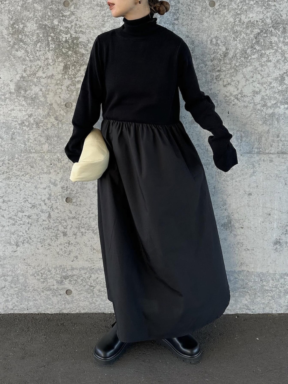 ブラック系のワンピース、ベージュ系のハンドバッグ、ブラック系のスリッポンを着用したレディースの冬コーディネートの3枚目の写真