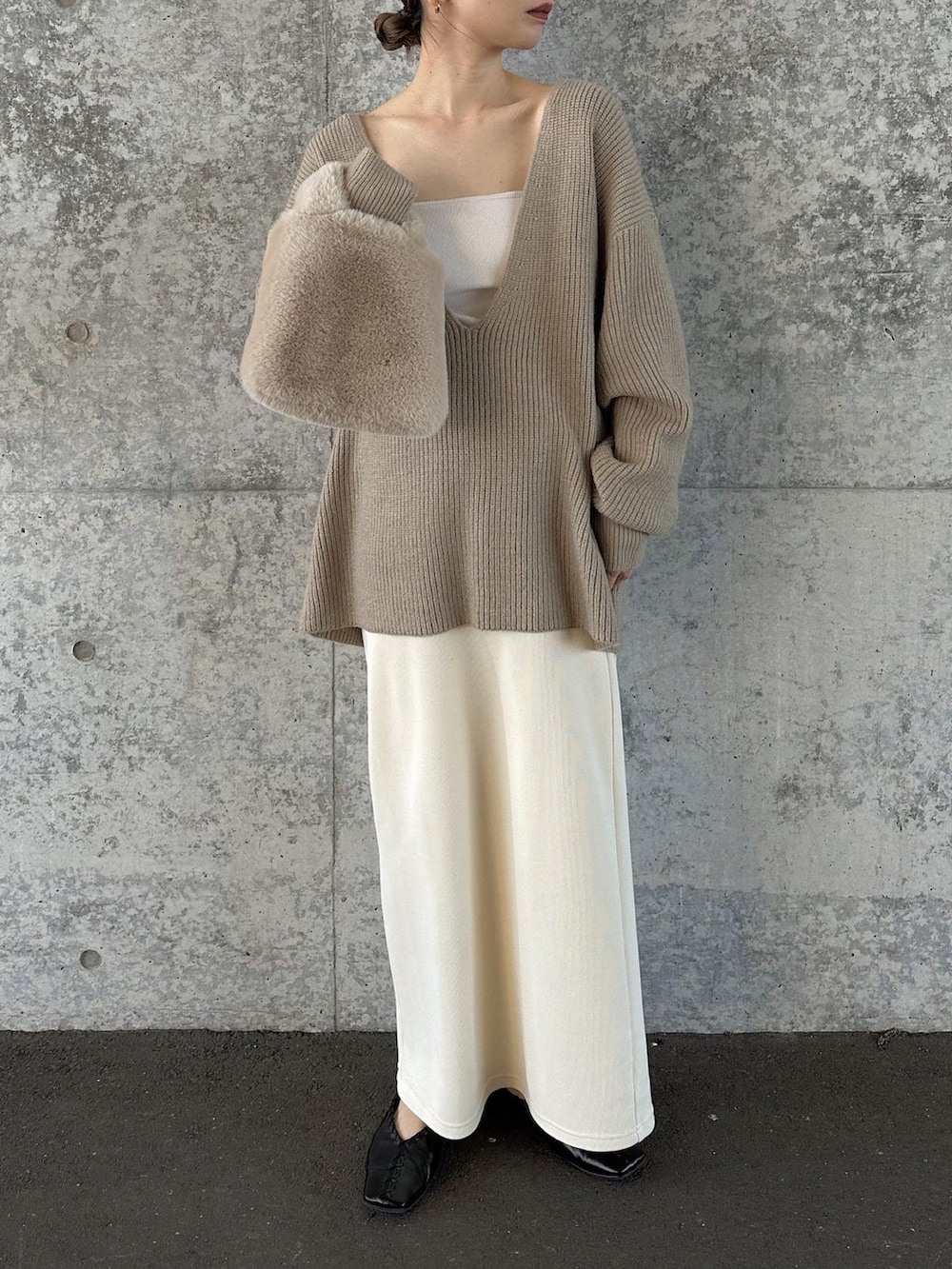 ベージュ系のニット/セーター、ホワイト系のスカート、ベージュ系のトートバッグを着用したレディースの秋コーディネートの4枚目の写真