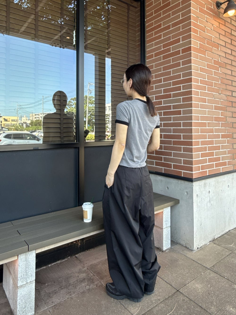 グレー系のTシャツ/カットソー、ブラック系のその他パンツ、ブラック系のハンドバッグを着用したレディースの秋コーディネートの4枚目の写真