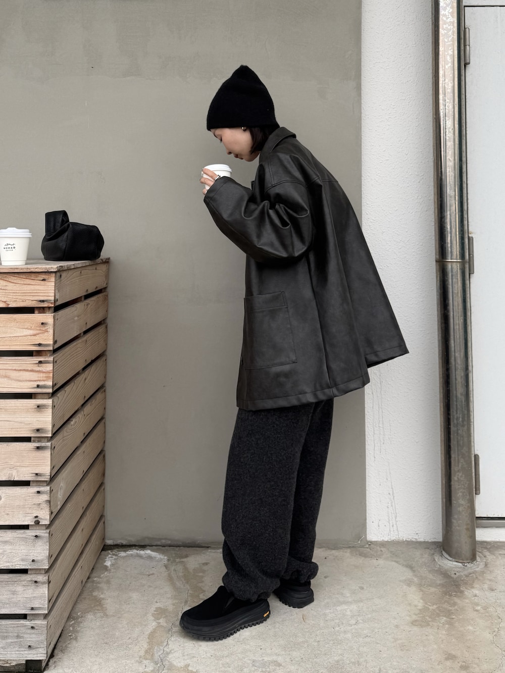 ブラック系のステンカラーコート、グレー系のデニムパンツ、ブラック系のその他シューズを着用したレディースの冬コーディネートの5枚目の写真