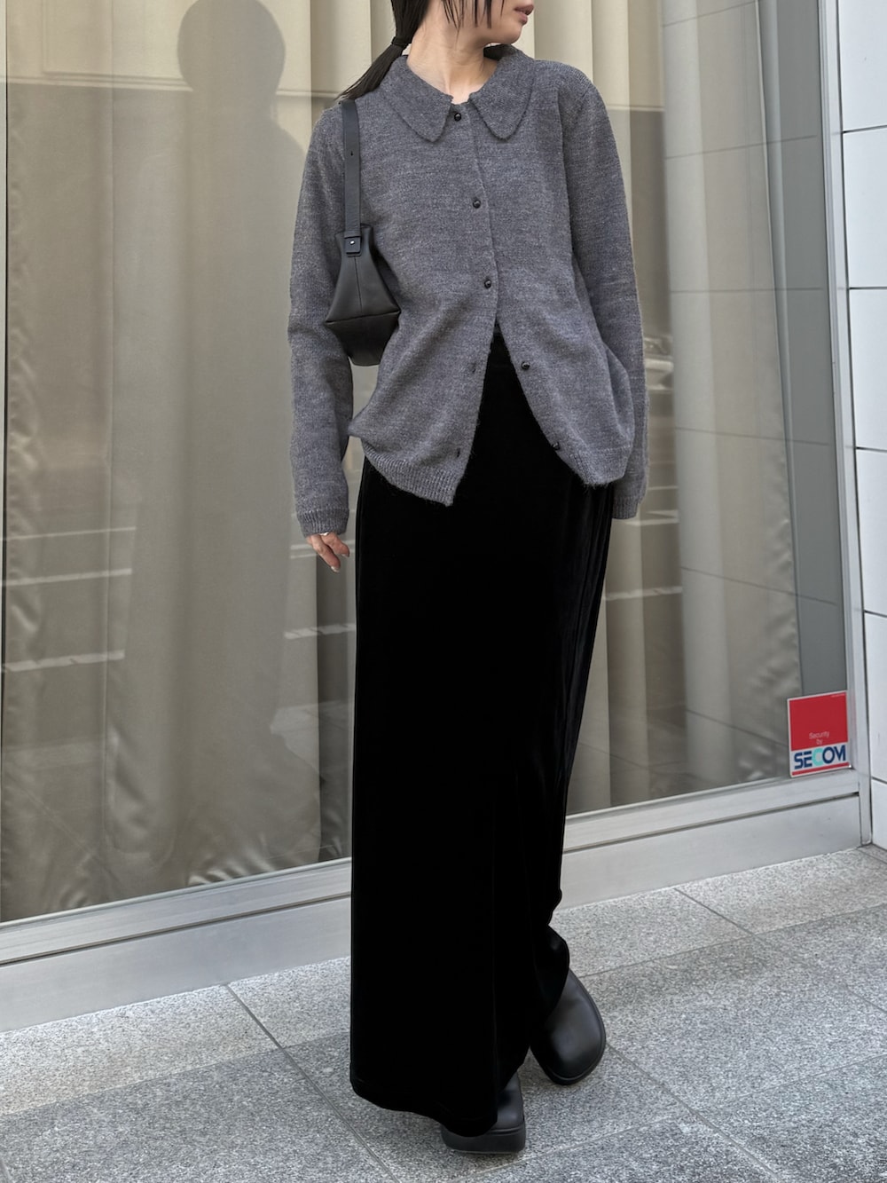 ブラック系のスカート、ブラック系のローファーを着用したレディースの冬コーディネートの2枚目の写真