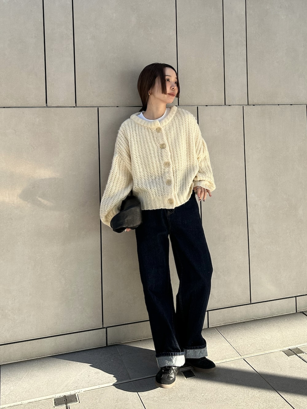 ホワイト系のカーディガン/ボレロ、ホワイト系のTシャツ/カットソー、ブルー系のデニムパンツを着用したレディースの冬コーディネートの5枚目の写真