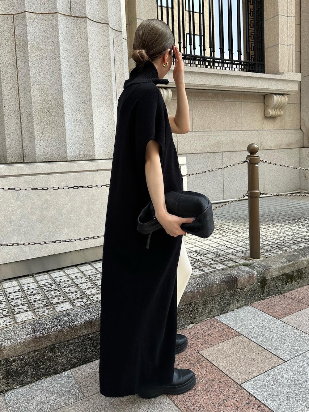 ブラック系のワンピース、ホワイト系のスカート、ブラック系のハンドバッグを着用したレディースの秋コーディネートの2枚目の写真