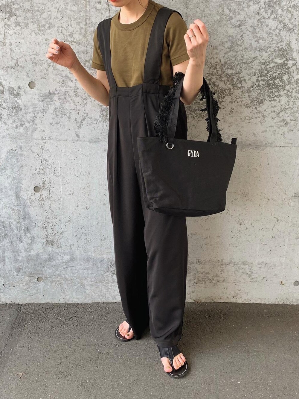 ブラック系のトートバッグ、ブラック系のサロペット/オーバーオール、ホワイト系のTシャツ/カットソーを着用したレディースの夏コーディネートの2枚目の写真