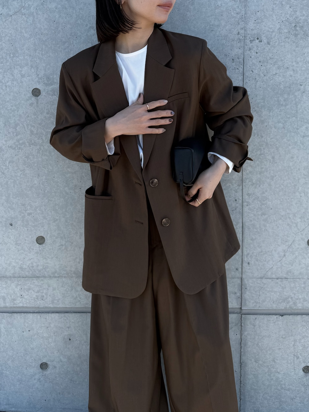 ブラウン系のテーラードジャケット、ホワイト系のシャツ/ブラウス、ブラウン系のスラックスを着用したレディースの冬コーディネートの2枚目の写真