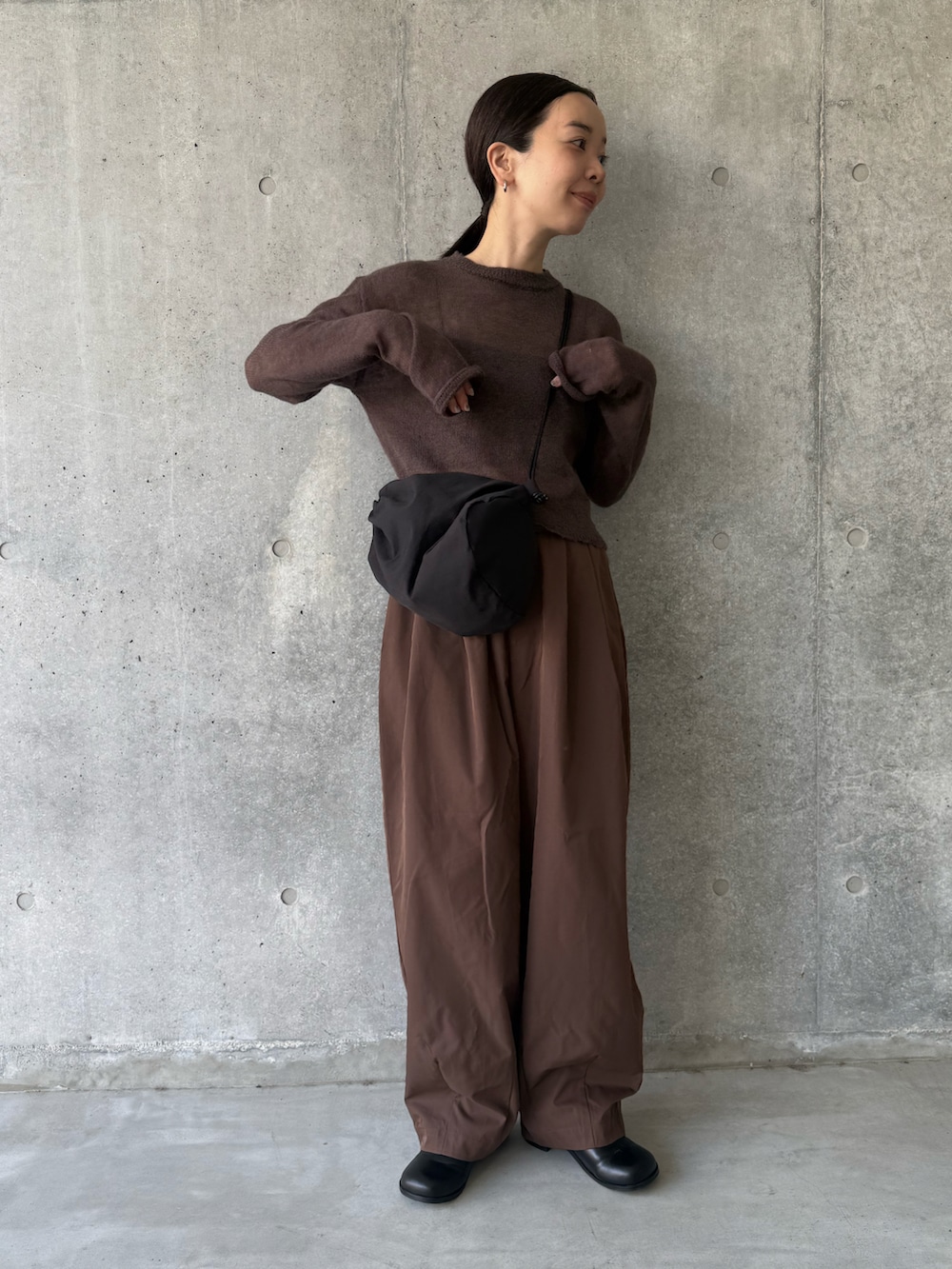 ブラウン系のニット/セーター、ブラウン系のその他パンツ、ブラック系のショルダーバッグを着用したレディースの秋コーディネートの3枚目の写真