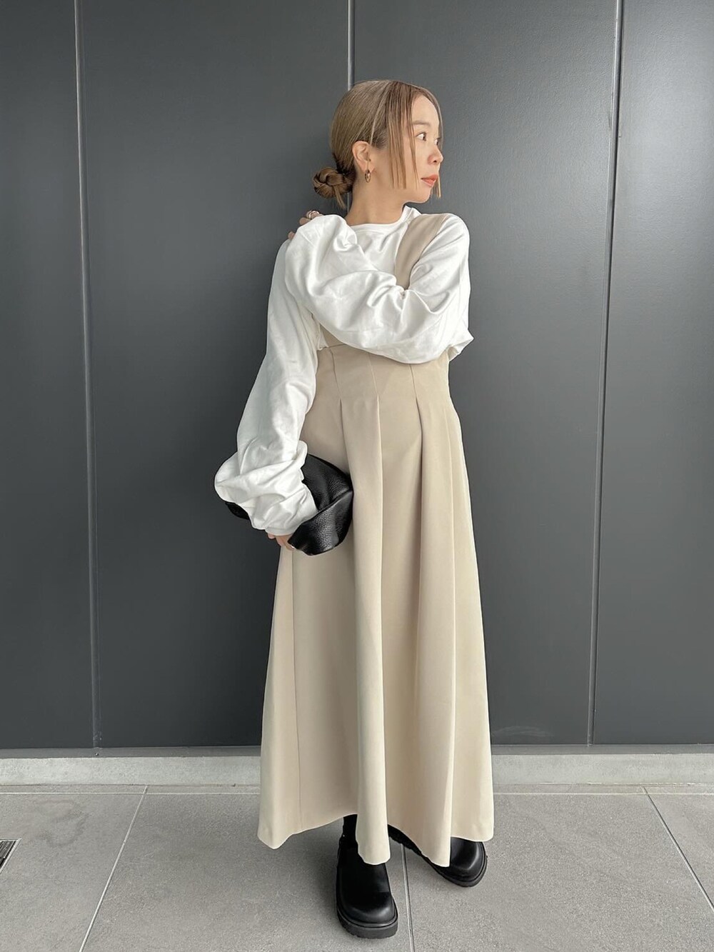 ベージュ系のスカート、ホワイト系のTシャツ/カットソー、ブラック系のスリッポンを着用したレディースの冬コーディネートの4枚目の写真