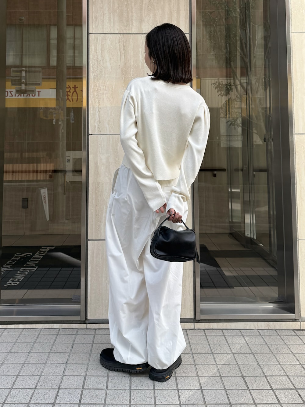 ホワイト系のカーディガン/ボレロ、ブラック系のその他パンツ、ブラック系のその他シューズを着用したレディースの冬コーディネートの4枚目の写真