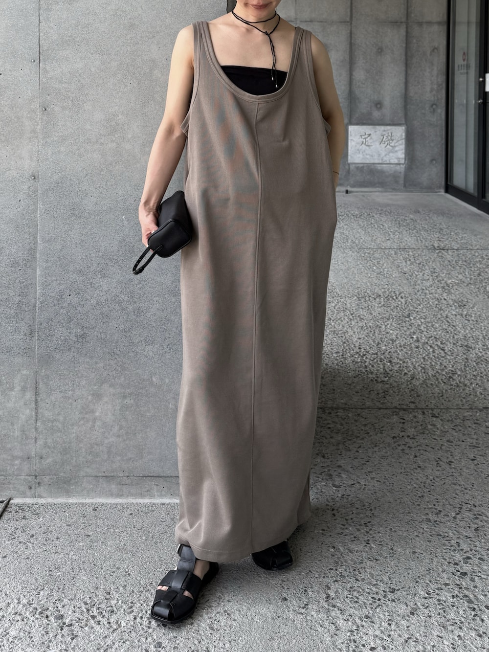 ベージュ系のワンピース、ブラック系のネックレスを着用したレディースの夏コーディネートの5枚目の写真