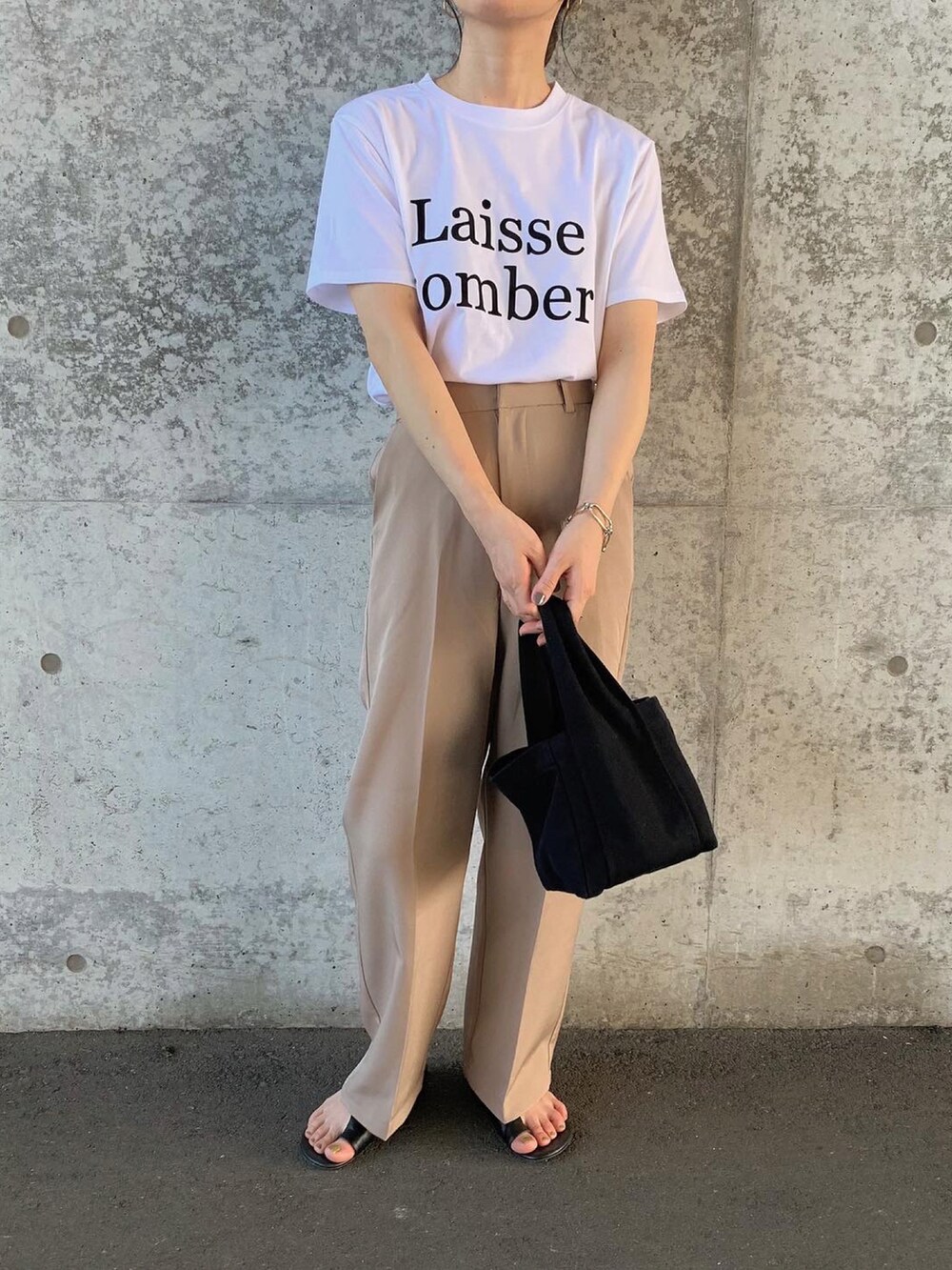 ホワイト系のTシャツ/カットソー、ベージュ系のスラックス、ブラック系のトートバッグを着用したレディースの夏コーディネートの2枚目の写真