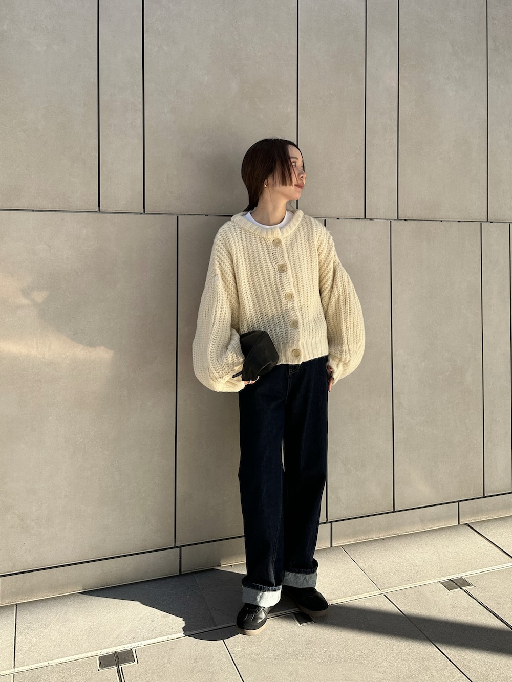 ホワイト系のカーディガン/ボレロ、ホワイト系のTシャツ/カットソー、ブルー系のデニムパンツを着用したレディースの冬コーディネートの2枚目の写真