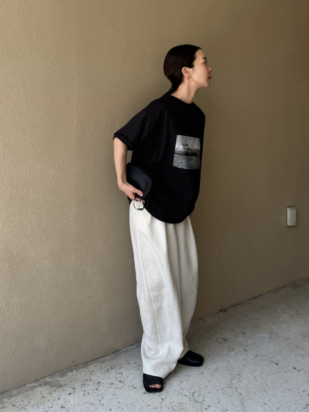 ブラック系のTシャツ/カットソー、ホワイト系のその他パンツ、ブラック系のサンダルを着用したレディースの夏コーディネートの2枚目の写真