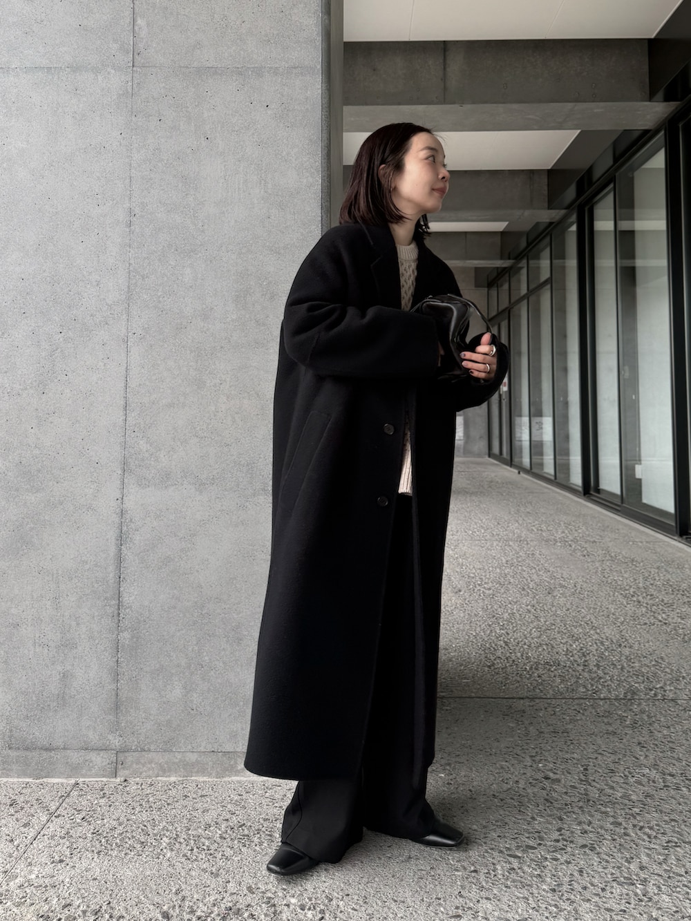 ホワイト系のニット/セーター、ブラック系のチェスターコート、ブラック系のその他パンツを着用したレディースの冬コーディネートの3枚目の写真