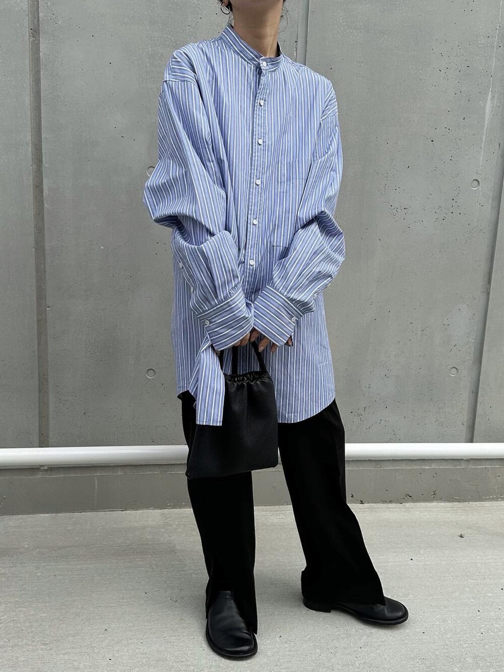 ブラック系のパンツ、ブルー系のシャツ/ブラウス、ブラック系のハンドバッグを着用したレディースの春コーディネートの4枚目の写真