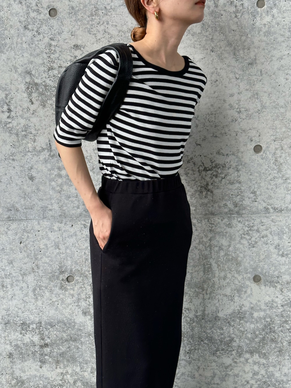 ブラック系のTシャツ/カットソー、ブラック系のスカート、ブラック系のサンダルを着用したレディースの夏コーディネートの4枚目の写真