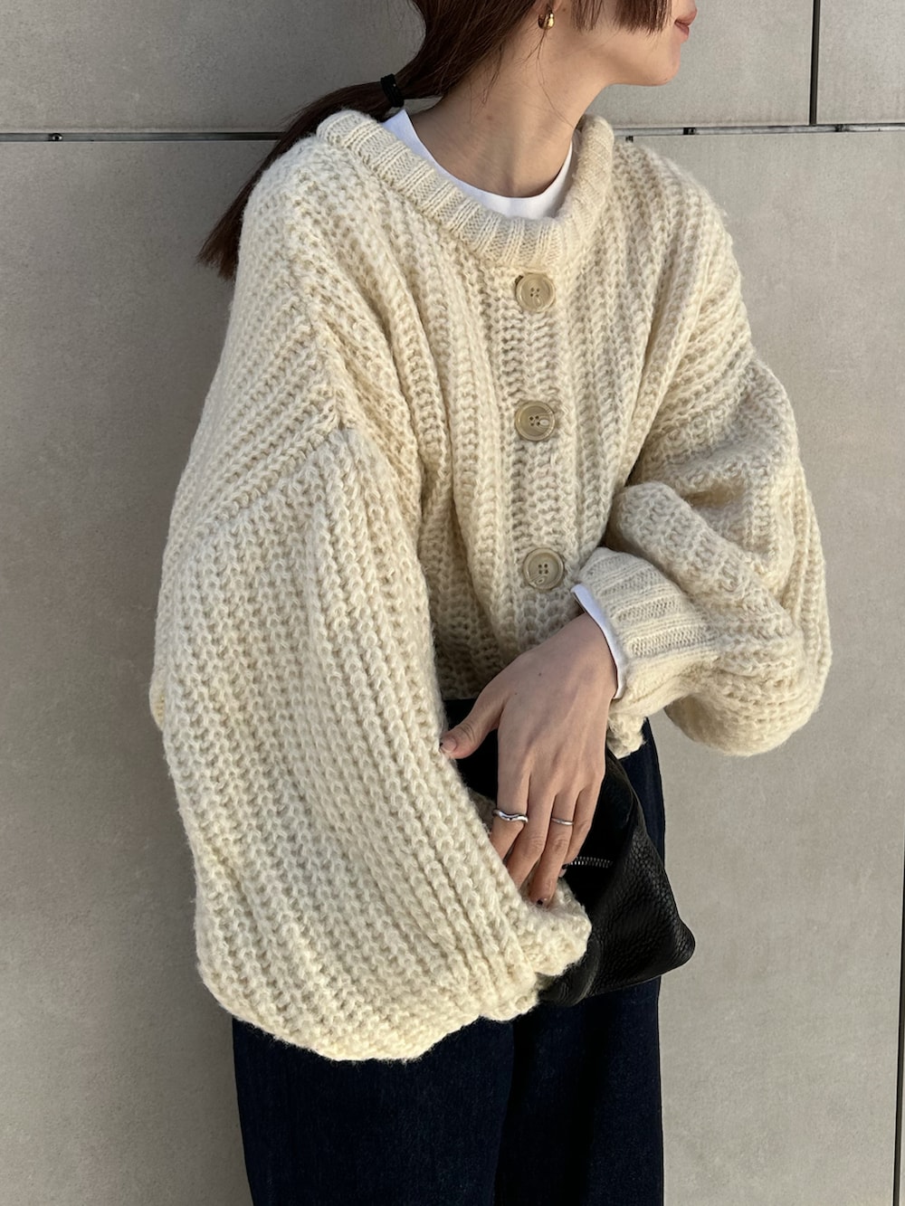 ホワイト系のカーディガン/ボレロ、ホワイト系のTシャツ/カットソー、ブルー系のデニムパンツを着用したレディースの冬コーディネートの4枚目の写真