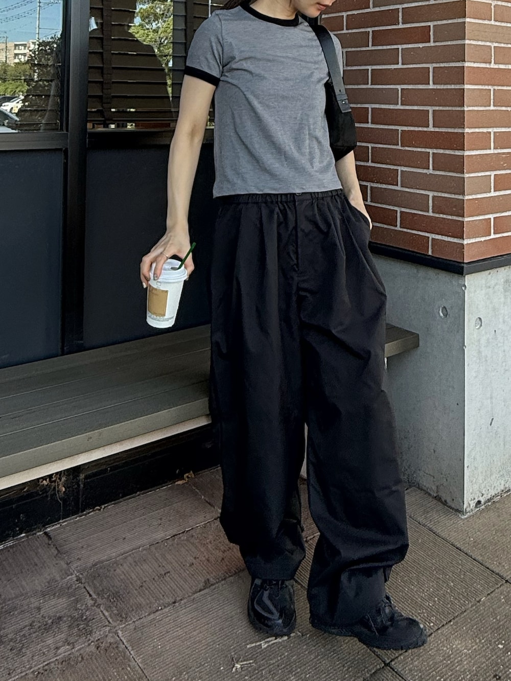 グレー系のTシャツ/カットソー、ブラック系のその他パンツ、ブラック系のハンドバッグを着用したレディースの秋コーディネートの3枚目の写真