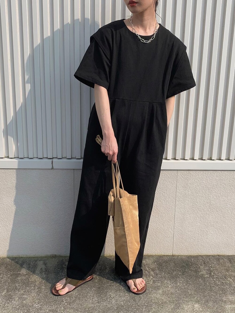 ブラック系のサロペット/オーバーオール、イエロー系のトートバッグ、イエロー系のサンダルを着用したレディースの夏コーディネートの2枚目の写真