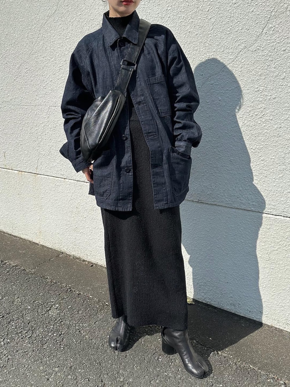 ブルー系のデニムジャケット、ブラック系のショルダーバッグ、ブラック系のニット/セーターを着用したレディースの冬コーディネートの5枚目の写真