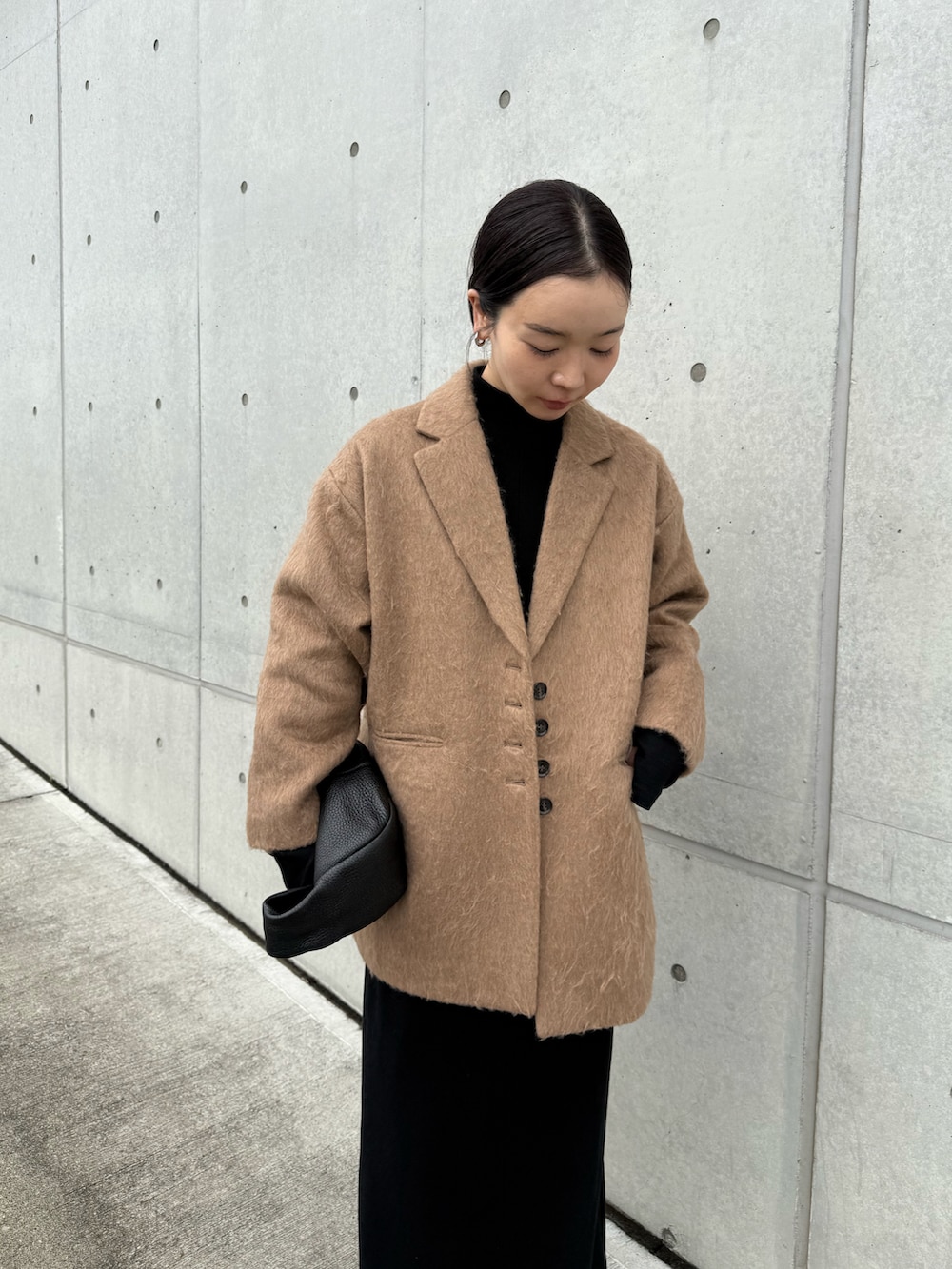 ブラウン系のテーラードジャケット、ブラック系のワンピース、ブラック系のスニーカーを着用したレディースの秋コーディネートの2枚目の写真