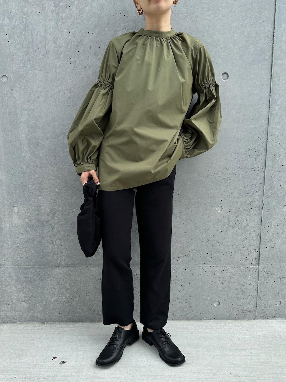 グリーン系のシャツ/ブラウス、ブラック系のその他パンツ、ブラック系のハンドバッグを着用したレディースの秋コーディネートの5枚目の写真