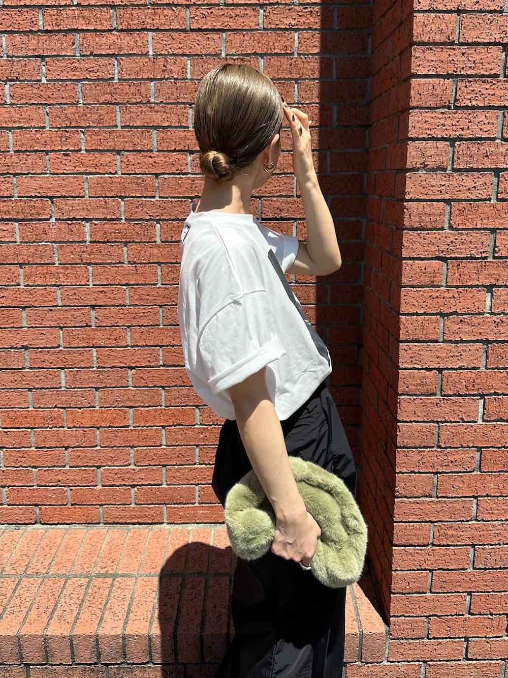 ホワイト系のTシャツ/カットソー、ブラック系のブーツ、グリーン系のハンドバッグを着用したレディースの夏コーディネートの5枚目の写真