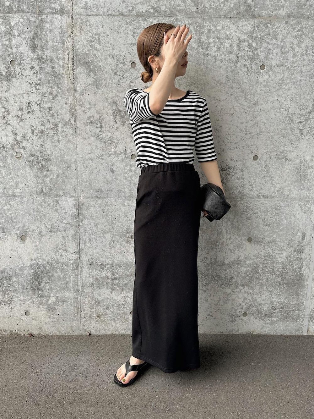 ブラック系のTシャツ/カットソー、ブラック系のスカート、ブラック系のサンダルを着用したレディースの夏コーディネートの2枚目の写真