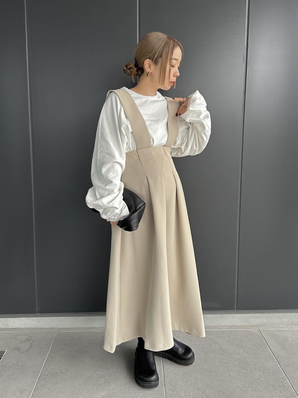 ベージュ系のスカート、ホワイト系のTシャツ/カットソー、ブラック系のスリッポンを着用したレディースの冬コーディネートの3枚目の写真