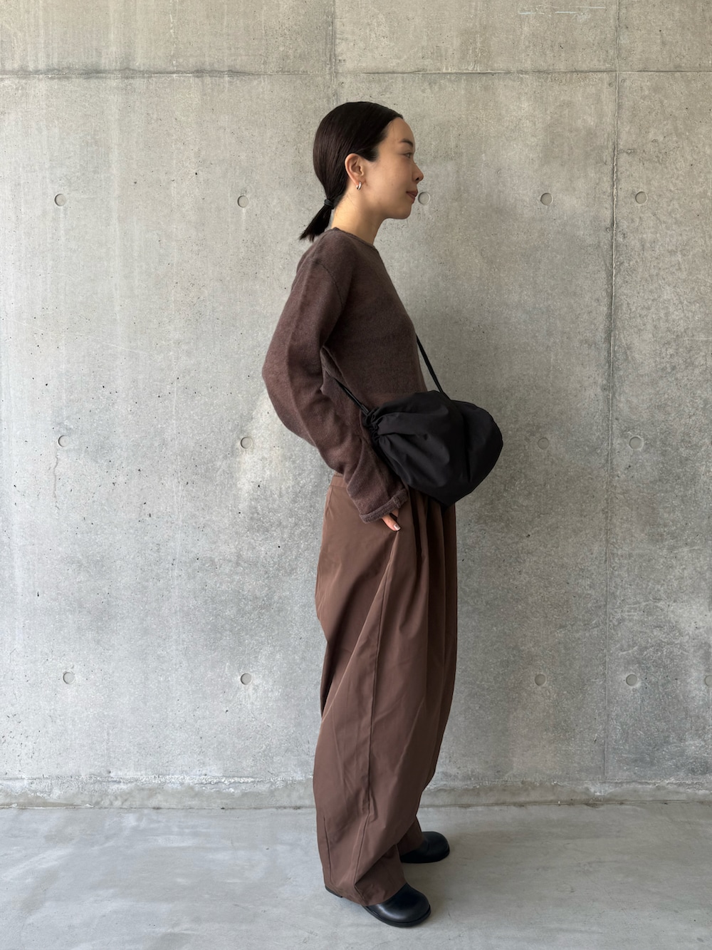 ブラウン系のニット/セーター、ブラウン系のその他パンツ、ブラック系のショルダーバッグを着用したレディースの秋コーディネートの2枚目の写真
