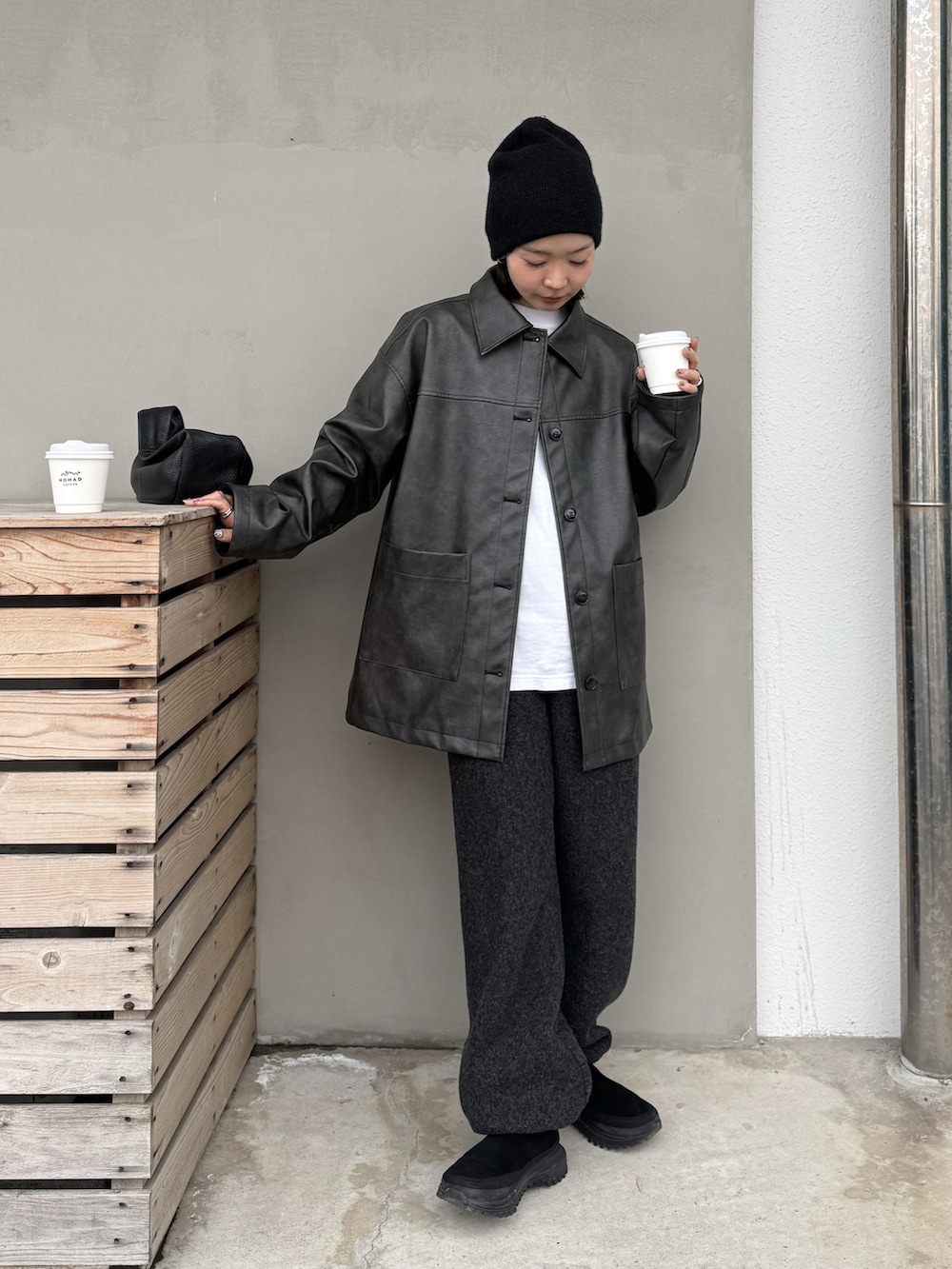 ブラック系のステンカラーコート、グレー系のデニムパンツ、ブラック系のその他シューズを着用したレディースの冬コーディネートの4枚目の写真