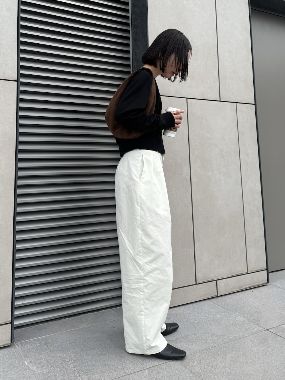 ブラック系のTシャツ/カットソー、ホワイト系のその他パンツ、ブラウン系のハンドバッグを着用したレディースの春コーディネートの3枚目の写真