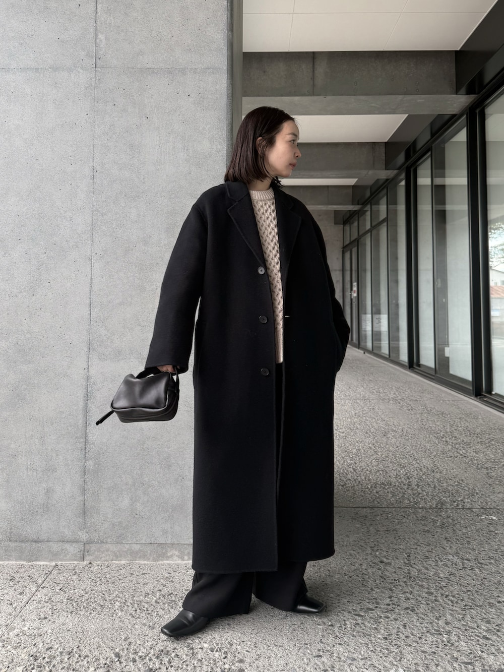 ホワイト系のニット/セーター、ブラック系のチェスターコート、ブラック系のその他パンツを着用したレディースの冬コーディネートの4枚目の写真
