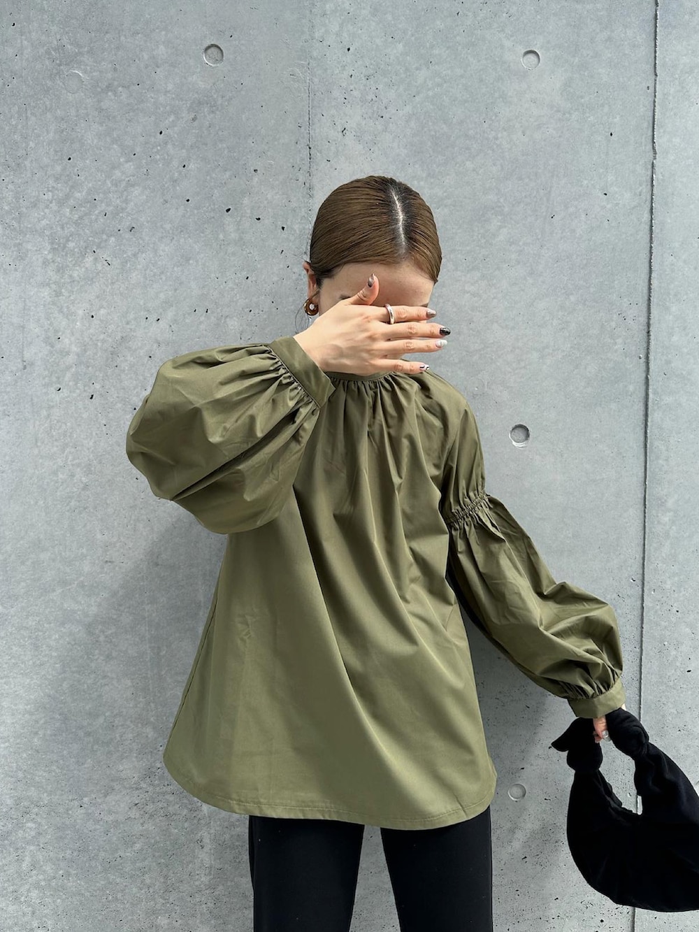 グリーン系のシャツ/ブラウス、ブラック系のその他パンツ、ブラック系のハンドバッグを着用したレディースの秋コーディネートの4枚目の写真