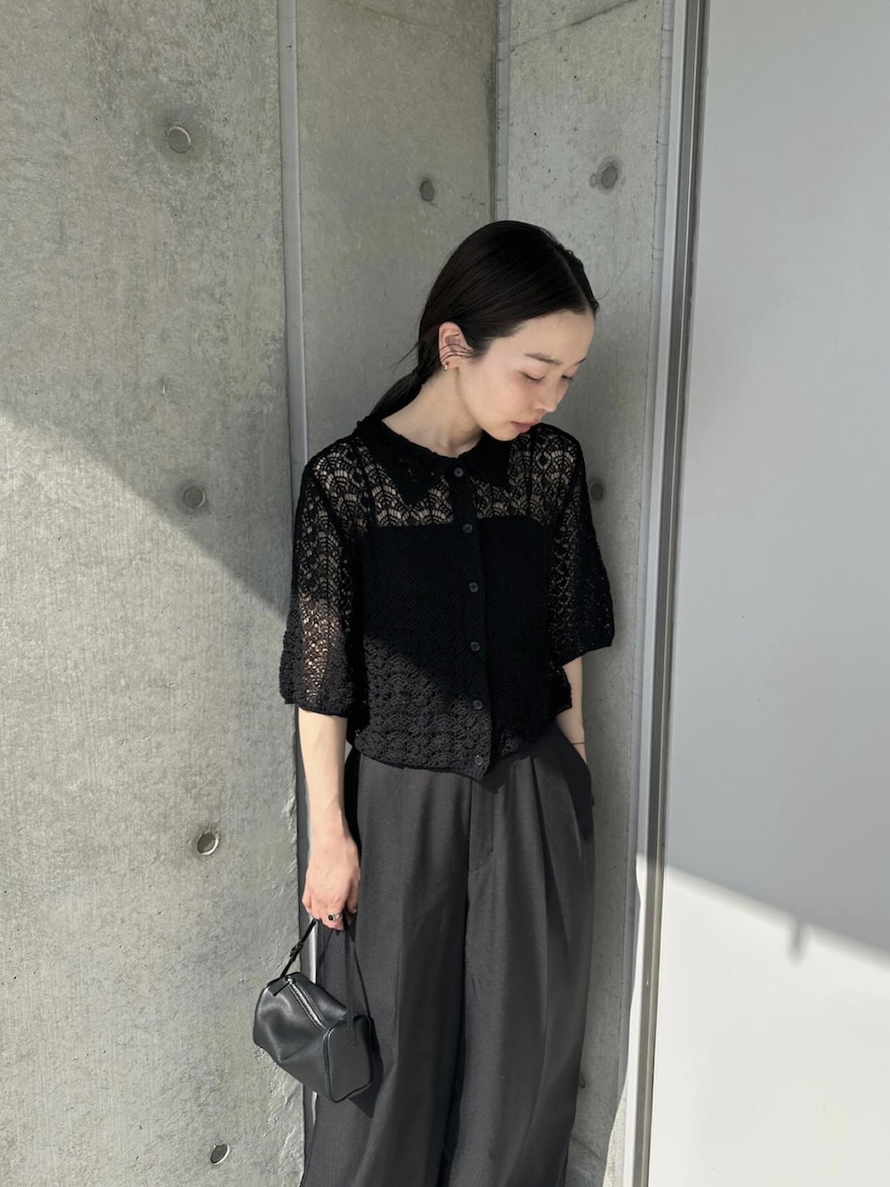 ブラック系のカーディガン/ボレロ、ブラック系のスラックス、ブラック系のスリッポンを着用したレディースの春コーディネートの2枚目の写真