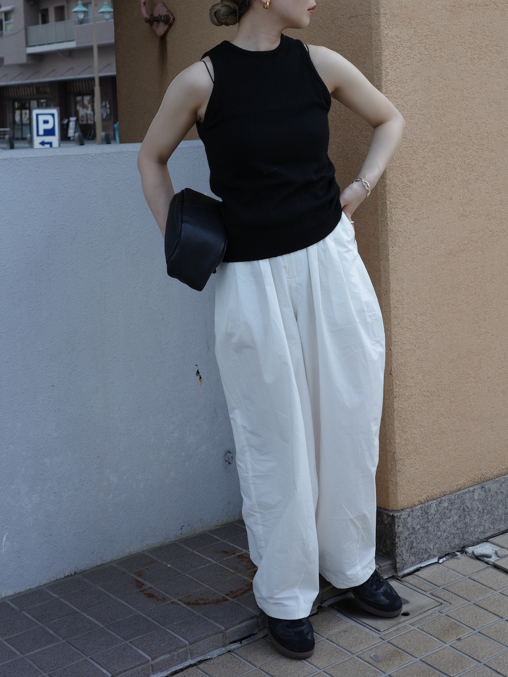 ブラック系のニット/セーター、ブラック系のキャミソール、ホワイト系のその他パンツを着用したレディースの夏コーディネートの4枚目の写真