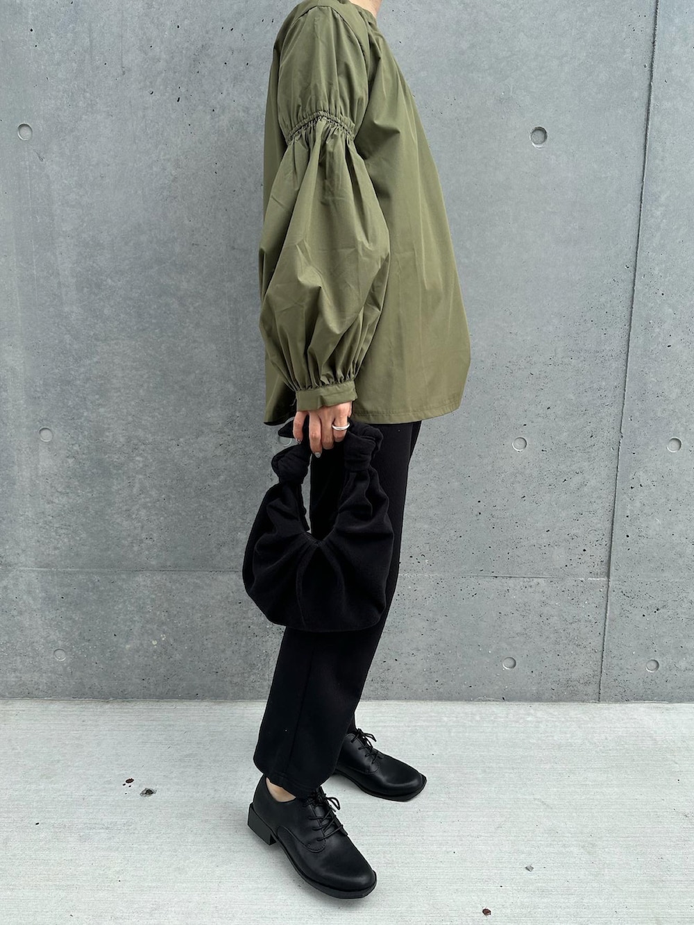 グリーン系のシャツ/ブラウス、ブラック系のその他パンツ、ブラック系のハンドバッグを着用したレディースの秋コーディネートの2枚目の写真