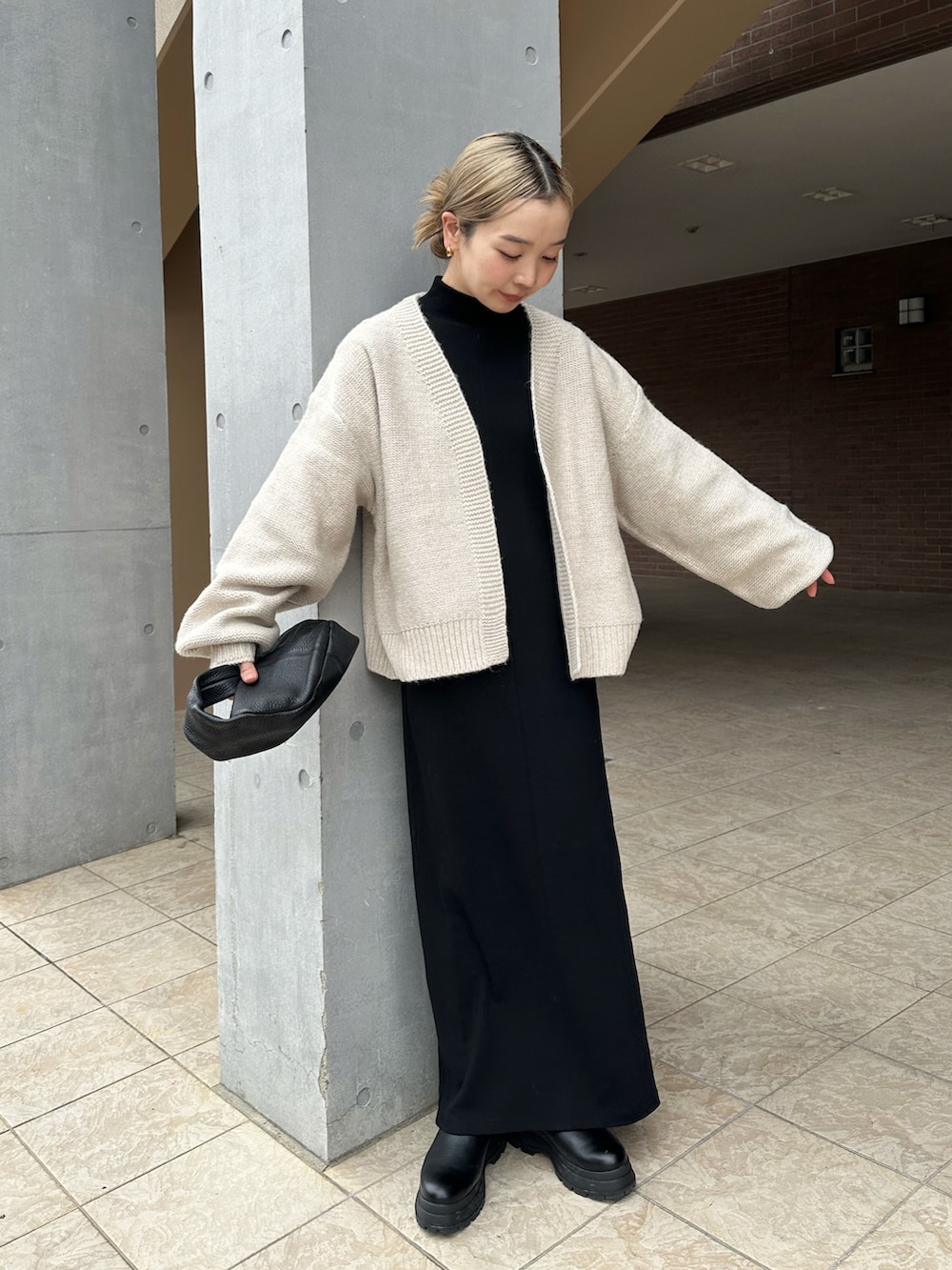 ホワイト系のカーディガン/ボレロ、ブラック系のワンピース、ブラック系のブーツを着用したレディースの秋コーディネートの2枚目の写真