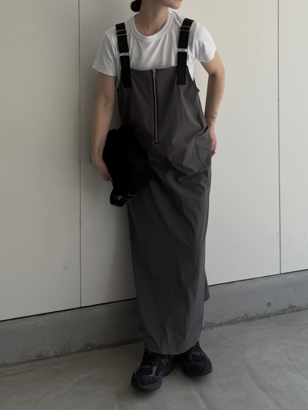 グレー系のジャンパースカート、ブラック系のハンドバッグを着用したレディースの夏コーディネートの2枚目の写真