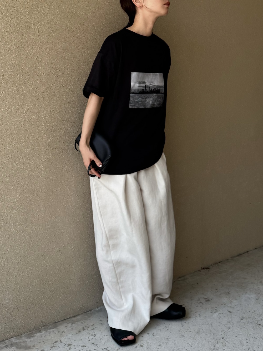 ブラック系のTシャツ/カットソー、ホワイト系のその他パンツ、ブラック系のサンダルを着用したレディースの夏コーディネートの3枚目の写真