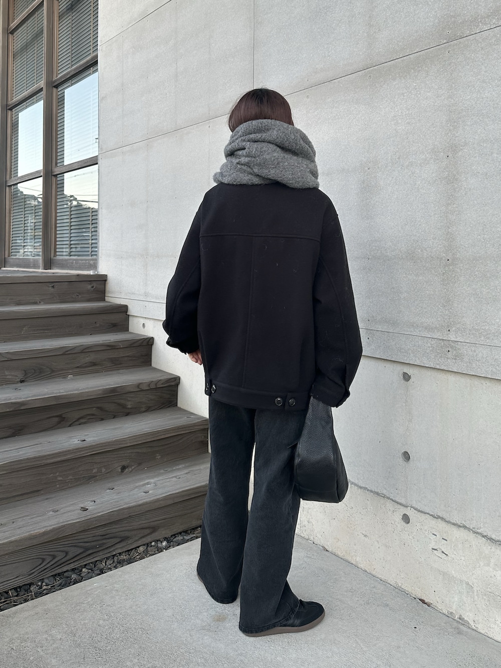 ブラック系のその他アウター、ブラック系のデニムパンツ、ブラック系のスニーカーを着用したレディースの冬コーディネートの2枚目の写真