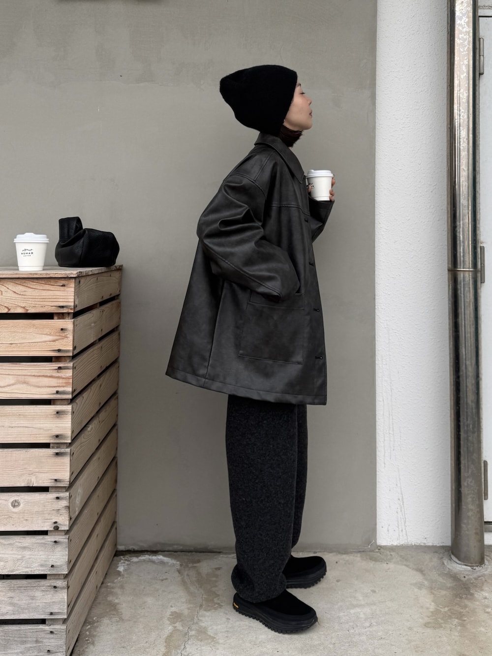 ブラック系のステンカラーコート、グレー系のデニムパンツ、ブラック系のその他シューズを着用したレディースの冬コーディネートの2枚目の写真